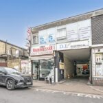Front exterior of 1a Totterdown Street development site in Tooting, SW17, showing barber shop and office entrance with vehicular access.