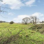 Front view of secluded development land on Vineyards Road, Northaw, Potters Bar, screened by mature trees for privacy in Hertfordshire commuter village