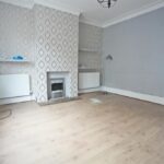 Expansive rear garden with patio, lawn and carport at 2-bed semi-detached investment property on Bedford Street, Elland